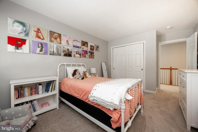 bedroom featuring light colored carpet, a closet, and baseboards