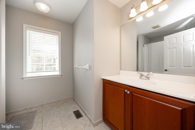 bathroom featuring tile patterned floors, visible vents, baseboards, and vanity