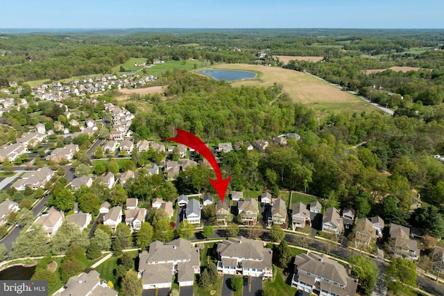 drone / aerial view featuring a water view, a forest view, and a residential view