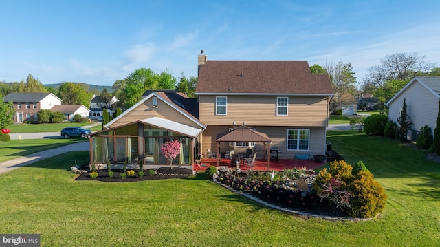 back of property featuring a lawn, a gazebo, and a chimney