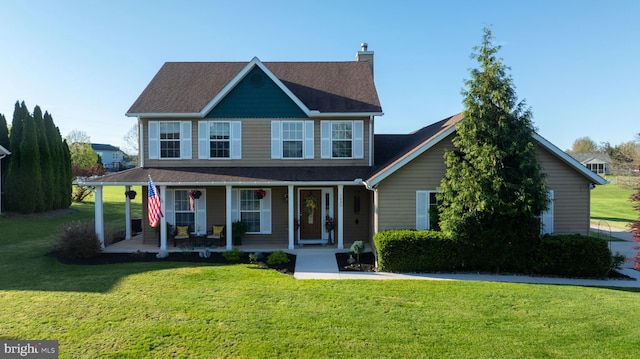 view of front of home featuring a porch, a chimney, a shingled roof, and a front yard