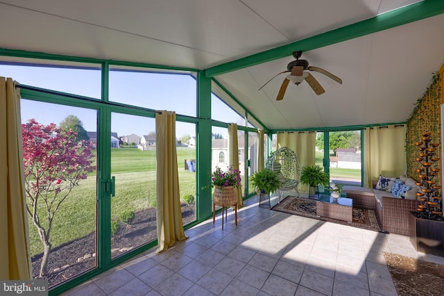 sunroom featuring ceiling fan, outdoor lounge area, and beam ceiling