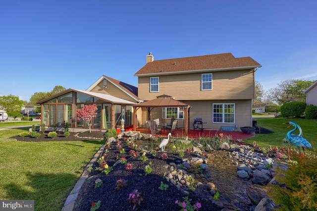 rear view of property featuring a chimney, a sunroom, a gazebo, a yard, and a patio
