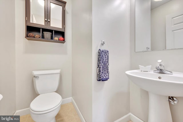 bathroom featuring baseboards, toilet, and tile patterned flooring