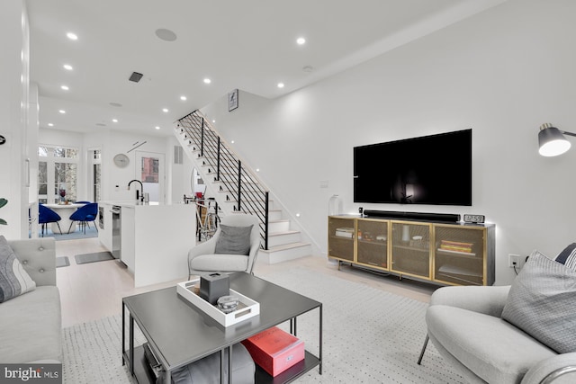 living room featuring stairs, recessed lighting, and light wood finished floors