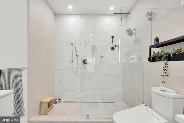 bathroom with tile walls and a marble finish shower