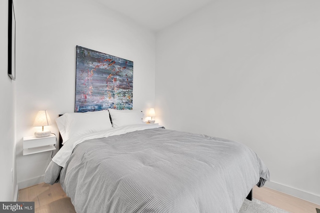 bedroom with baseboards and wood finished floors