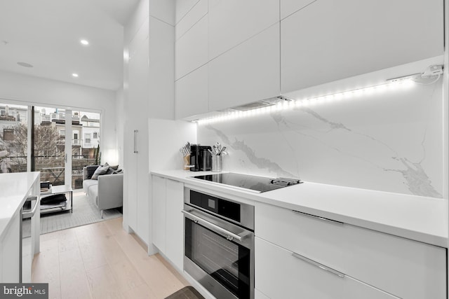kitchen with oven, modern cabinets, black electric stovetop, recessed lighting, and white cabinets
