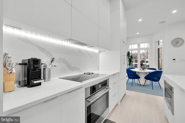 kitchen featuring recessed lighting, appliances with stainless steel finishes, modern cabinets, and white cabinets