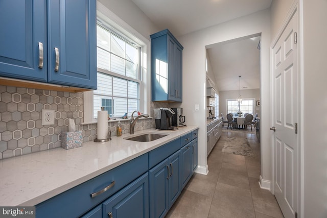 kitchen featuring blue cabinets, a sink, and light tile patterned floors