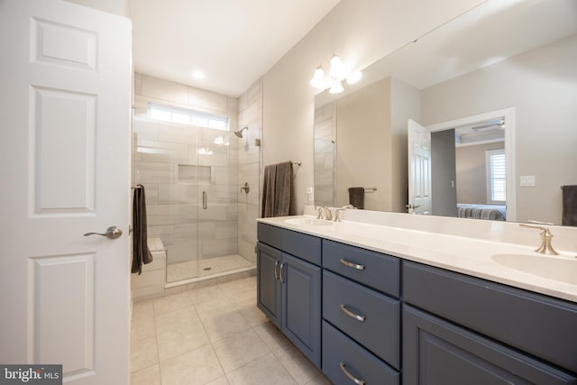 ensuite bathroom with a sink, tile patterned floors, ensuite bath, and double vanity
