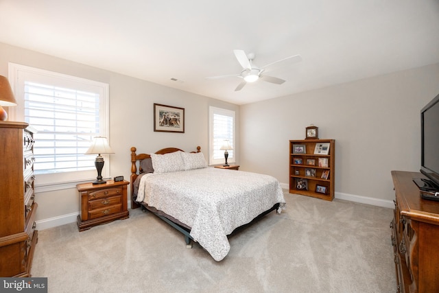 bedroom featuring baseboards, light carpet, and visible vents
