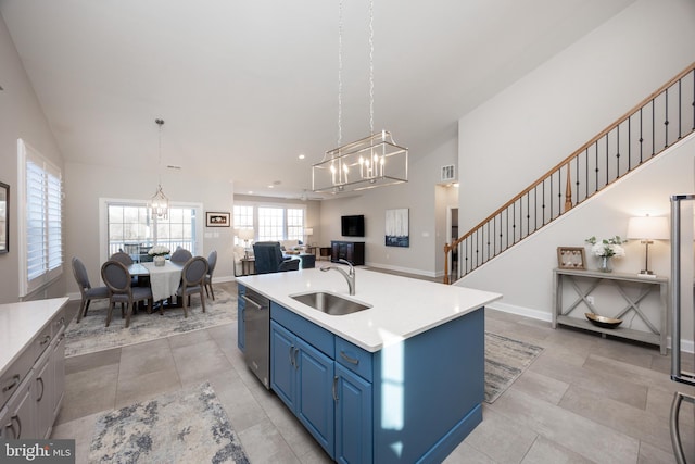 kitchen with an inviting chandelier, blue cabinets, a sink, and open floor plan