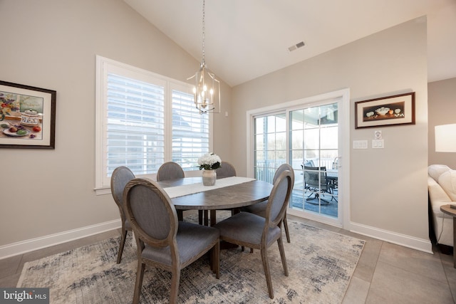 dining area with a notable chandelier, tile patterned floors, baseboards, vaulted ceiling, and visible vents
