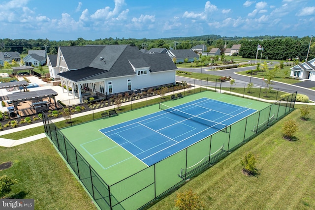 view of sport court with a lawn, fence, and a residential view