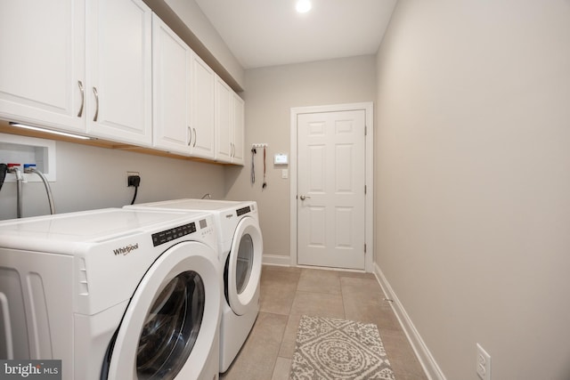 washroom featuring light tile patterned floors, baseboards, independent washer and dryer, and cabinet space