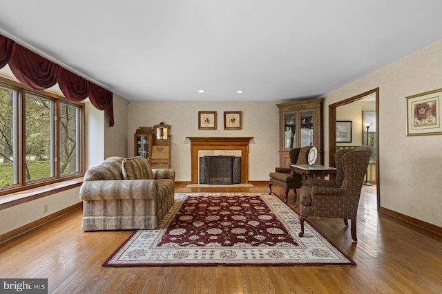 living room with baseboards, a fireplace, recessed lighting, and wood finished floors