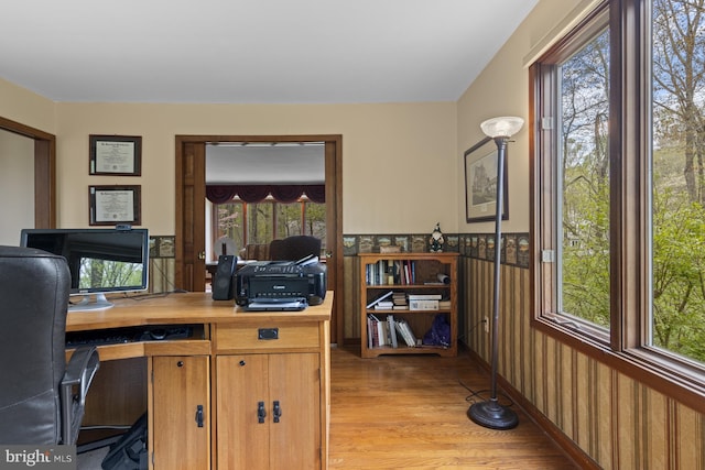 office with wallpapered walls, wainscoting, and light wood-style floors