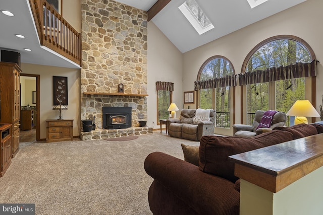 carpeted living room featuring a wealth of natural light, a skylight, and high vaulted ceiling