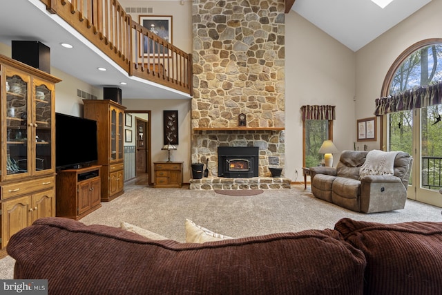 living area featuring light colored carpet, a healthy amount of sunlight, high vaulted ceiling, and visible vents