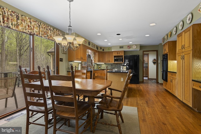 dining space featuring an inviting chandelier, recessed lighting, dark wood finished floors, and visible vents