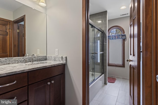 full bath with shower / bath combination with glass door, tile patterned flooring, vanity, baseboards, and visible vents