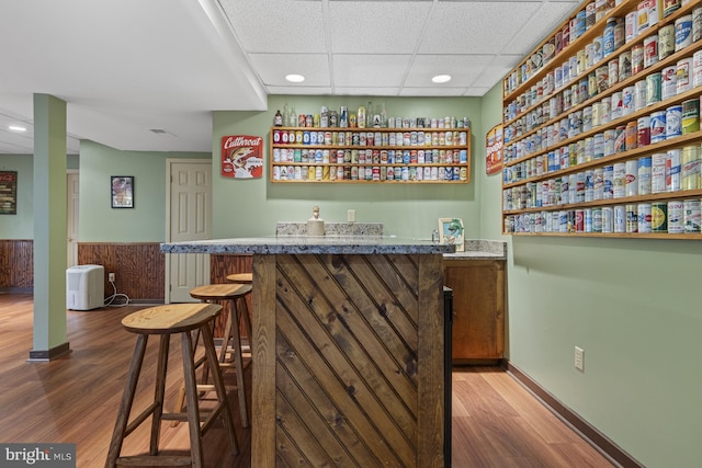 bar with indoor wet bar, recessed lighting, wainscoting, and wood finished floors