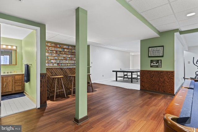 interior space with baseboards, a dry bar, and wood finished floors