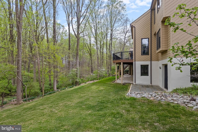 view of yard featuring a wooden deck and a patio