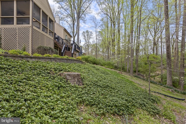 view of yard with stairway, ceiling fan, a wooden deck, and a sunroom