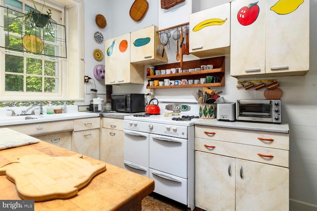 kitchen with black microwave, light countertops, a toaster, and range with two ovens