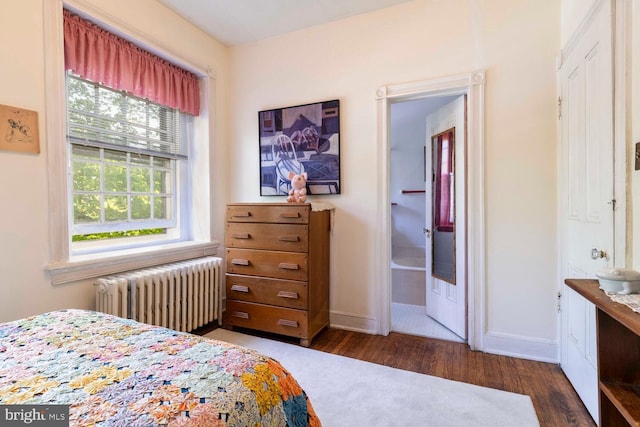 bedroom with baseboards, radiator heating unit, and wood finished floors