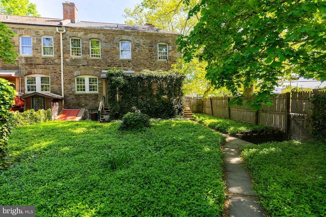 rear view of property with fence and a chimney