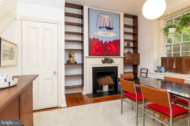 dining space featuring a fireplace and wood finished floors