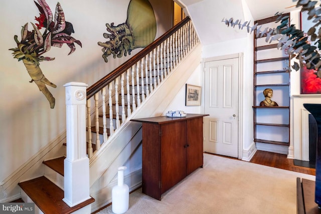 stairway featuring arched walkways and carpet