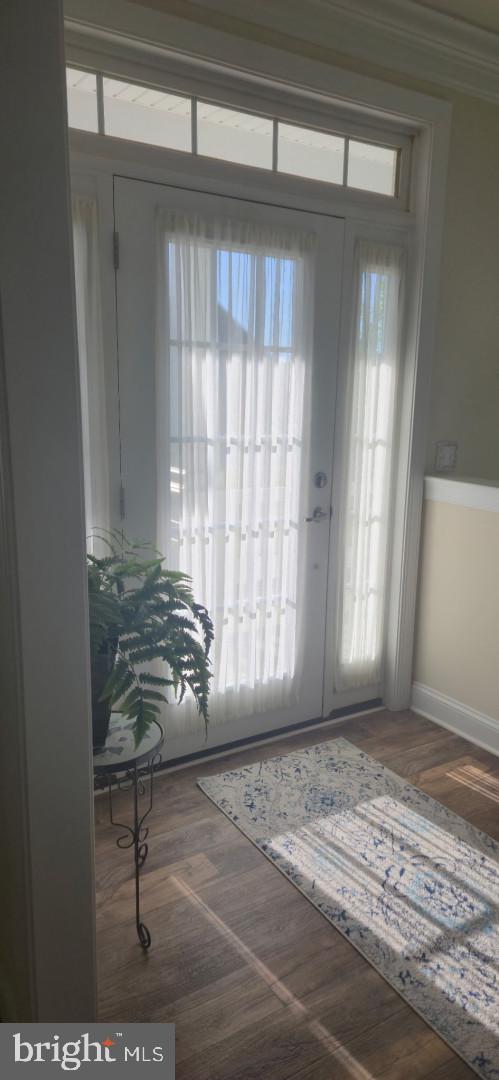 24840 Mistletoe Dr, Georgetown, DE 19947 - doorway to outside with crown molding, baseboards, and wood finished floors