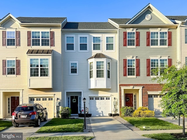 multi unit property featuring driveway and a garage