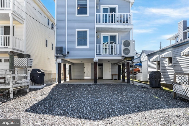 beach home with driveway, ac unit, a balcony, and a carport
