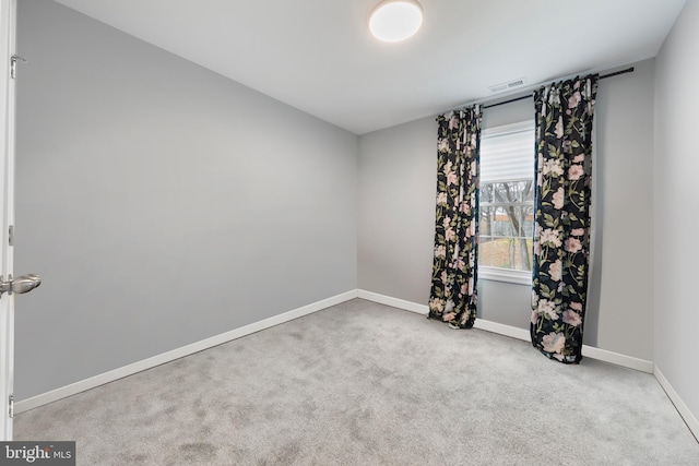 carpeted empty room featuring baseboards and visible vents