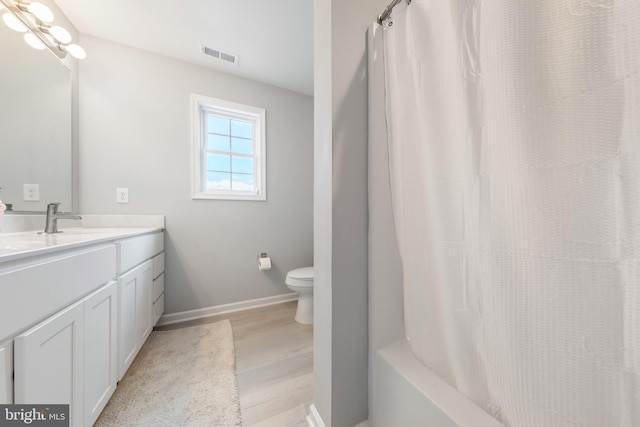 full bath with visible vents, wood finished floors, baseboards, vanity, and toilet
