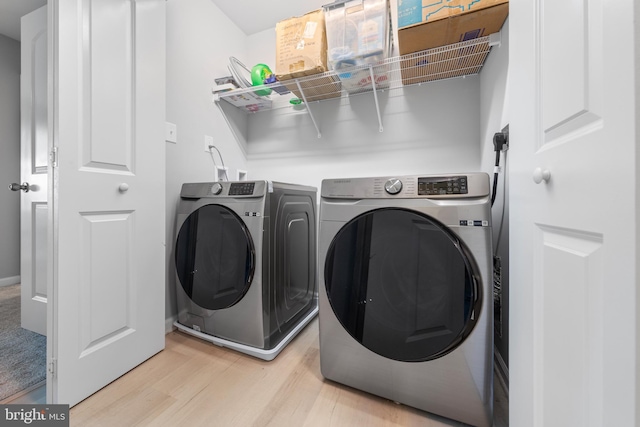 laundry room with separate washer and dryer, laundry area, and light wood-style floors
