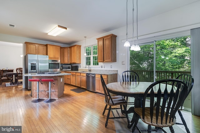 3001 Mandarin Pl, Waldorf, MD 20603 - kitchen with a kitchen island, decorative light fixtures, a sink, light wood-style floors, and stainless steel appliances