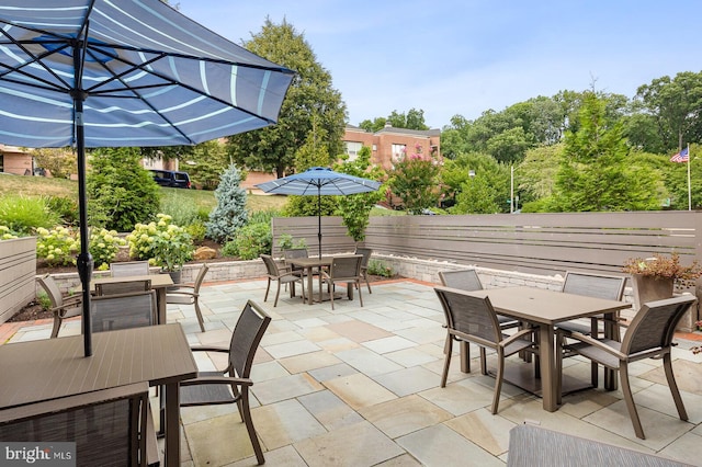 view of patio with outdoor dining area and fence
