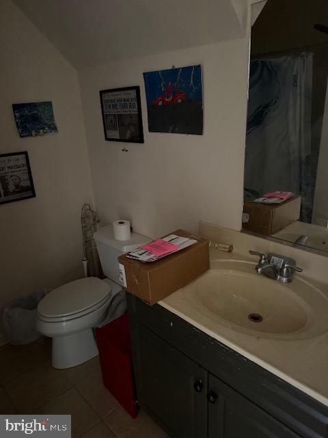 bathroom featuring vanity, tile patterned floors, and toilet