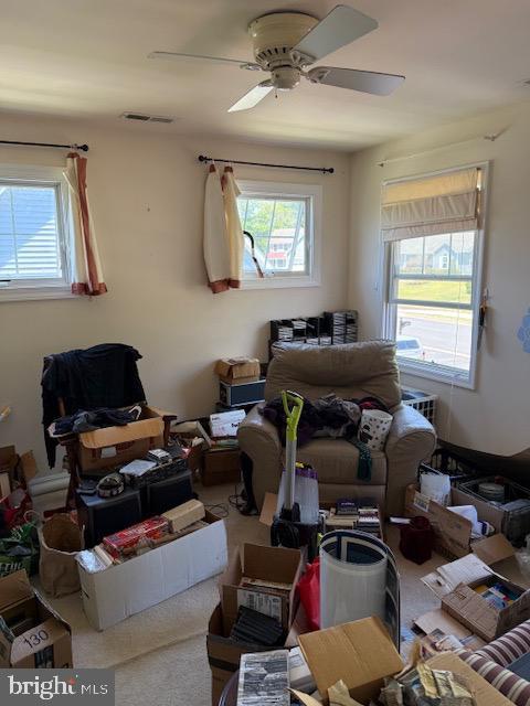 bedroom featuring multiple windows, a ceiling fan, and visible vents