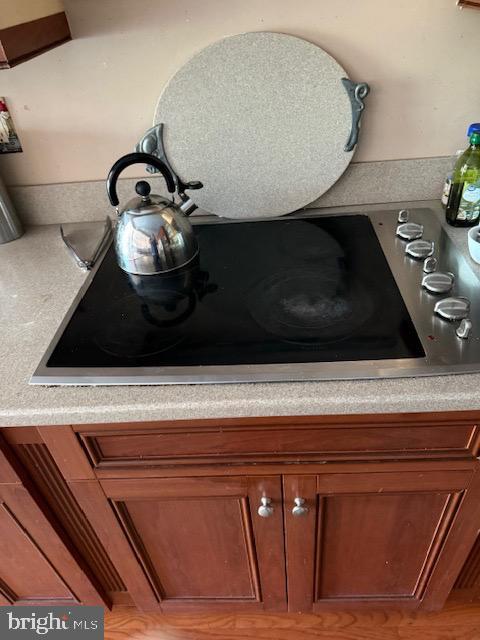 details featuring light countertops, black electric cooktop, and brown cabinetry