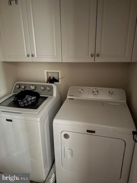 laundry area with cabinet space and separate washer and dryer