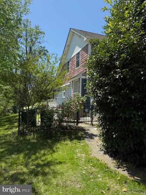 view of home's exterior with a yard and fence