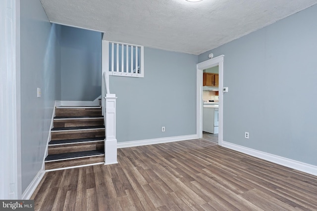 interior space with baseboards, a textured ceiling, and wood finished floors