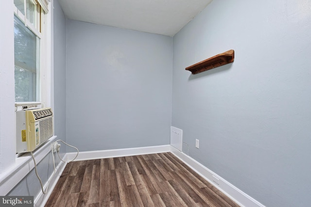 spare room featuring baseboards, dark wood finished floors, and cooling unit